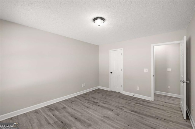 1071 N Price Rd, Sugar Hill, GA 30518 - unfurnished bedroom with wood finished floors and a textured ceiling