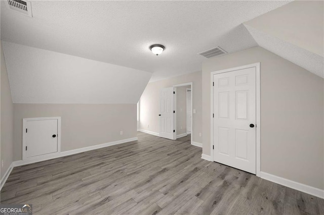 1071 N Price Rd, Sugar Hill, GA 30518 - additional living space featuring a textured ceiling, lofted ceiling, and wood finished floors