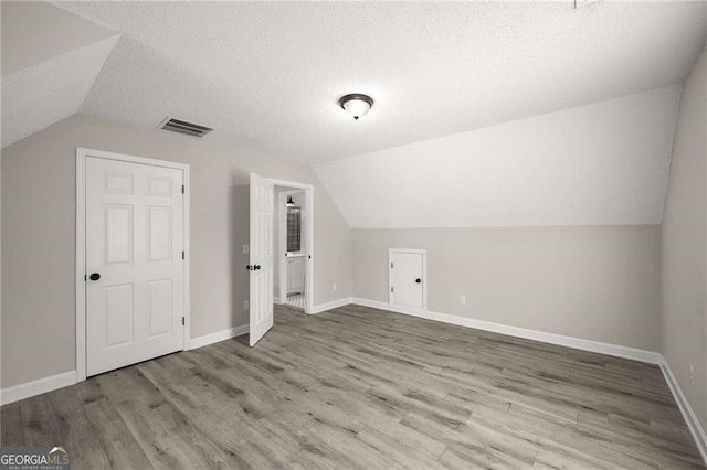 1071 N Price Rd, Sugar Hill, GA 30518 - additional living space featuring lofted ceiling, wood finished floors, and a textured ceiling