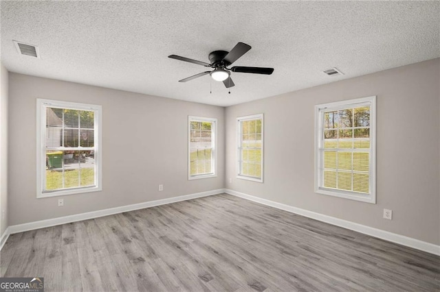 1071 N Price Rd, Sugar Hill, GA 30518 - spare room with wood finished floors, a textured ceiling, ceiling fan, and plenty of natural light