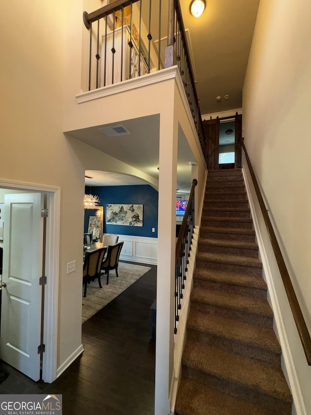 124 Gorham Gates Ct, Hiram, GA 30141 - stairway featuring wainscoting, wood finished floors, and a high ceiling