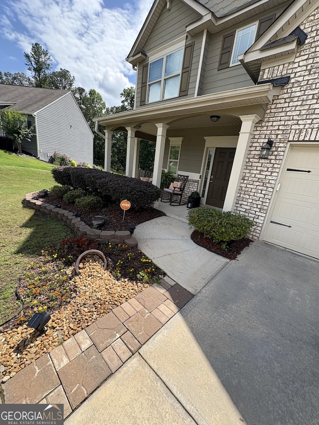124 Gorham Gates Ct, Hiram, GA 30141 - doorway to property featuring a porch, a lawn, and a garage