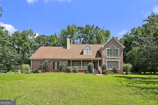 309 Cimarron Ct, Macon, GA 31220 - view of front of house featuring a porch, brick siding, a front yard, and a chimney