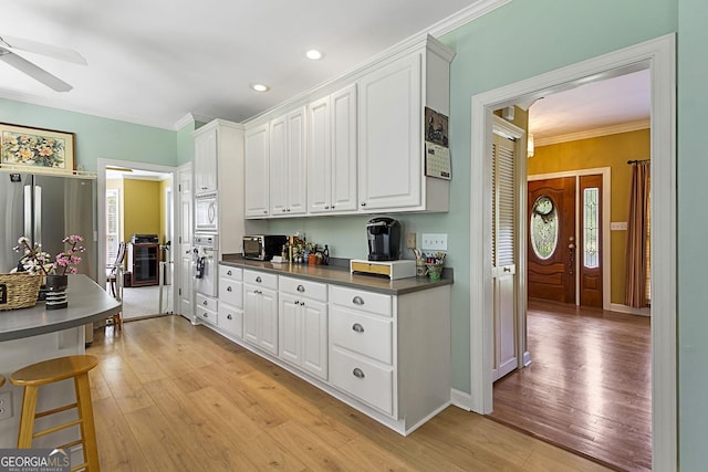309 Cimarron Ct, Macon, GA 31220 - kitchen with dark countertops, ornamental molding, light wood-style flooring, stainless steel oven, and ceiling fan