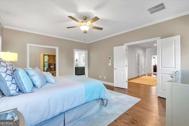 1099 Heyward Way, Alpharetta, GA 30009 - bedroom with wood finished floors, ornamental molding, connected bathroom, a walk in closet, and a ceiling fan
