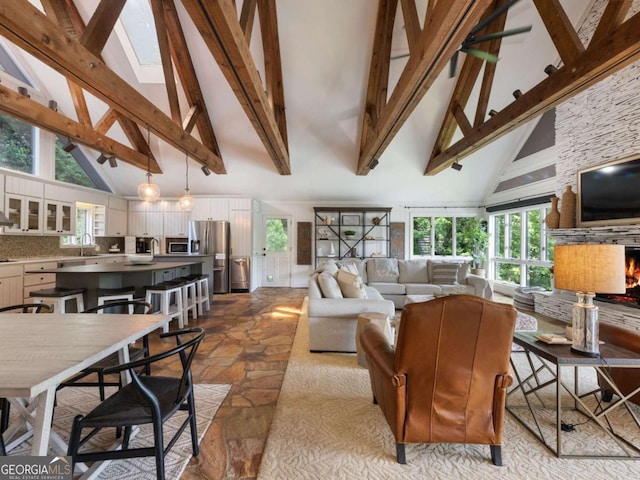 178 Rowland Pt, Morganton, GA 30560 - living area with high vaulted ceiling, stone finish flooring, beam ceiling, plenty of natural light, and a fireplace