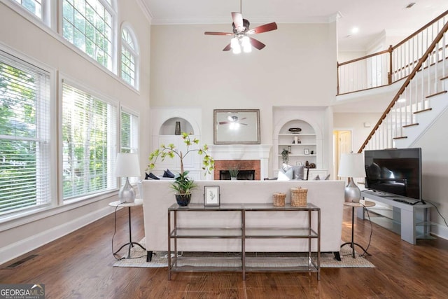 3741 Cape York Trce, Alpharetta, GA 30022 - living room with a towering ceiling, a ceiling fan, built in shelves, a fireplace, and ornamental molding