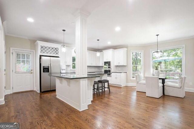 3741 Cape York Trce, Alpharetta, GA 30022 - kitchen with stainless steel fridge, a kitchen bar, dark countertops, crown molding, and white cabinets