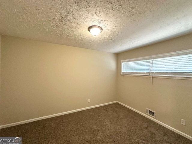 3456 Spring Cir, Decatur, GA 30032 - spare room with a textured ceiling, baseboards, and dark colored carpet