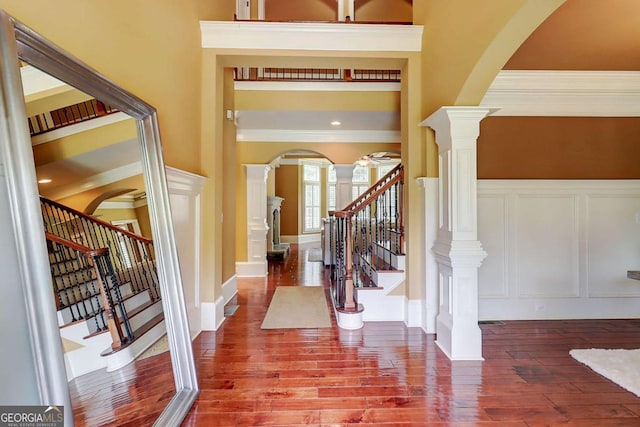 116 Archstone Sq, Mcdonough, GA 30253 - foyer entrance with arched walkways, ornate columns, ornamental molding, stairway, and hardwood / wood-style floors