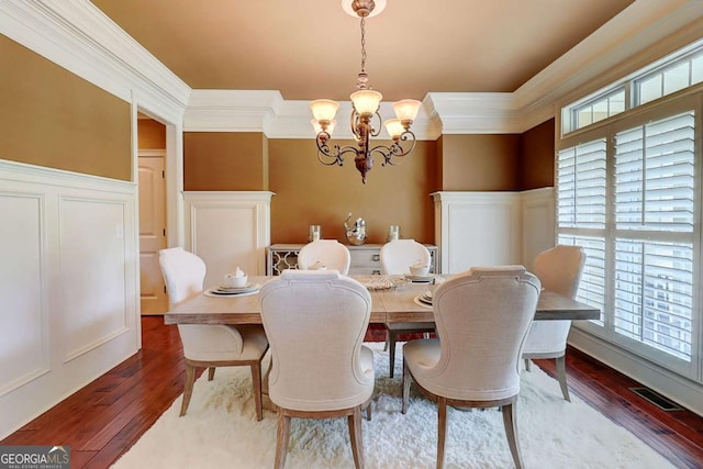 116 Archstone Sq, Mcdonough, GA 30253 - dining space with a chandelier, crown molding, wood-type flooring, a decorative wall, and wainscoting