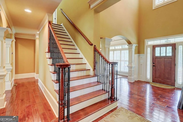 116 Archstone Sq, Mcdonough, GA 30253 - entrance foyer with ornate columns, wood-type flooring, arched walkways, stairs, and a high ceiling