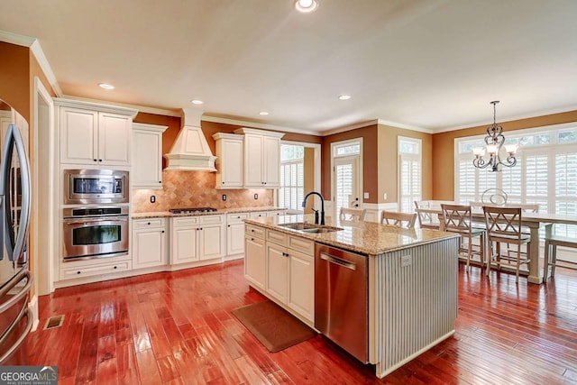 116 Archstone Sq, Mcdonough, GA 30253 - kitchen featuring stainless steel appliances, crown molding, hardwood / wood-style flooring, custom range hood, and backsplash