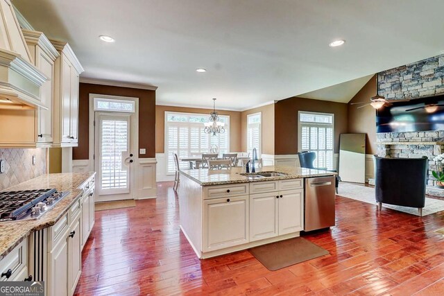 116 Archstone Sq, Mcdonough, GA 30253 - kitchen featuring premium range hood, stainless steel appliances, light wood finished floors, wainscoting, and a chandelier