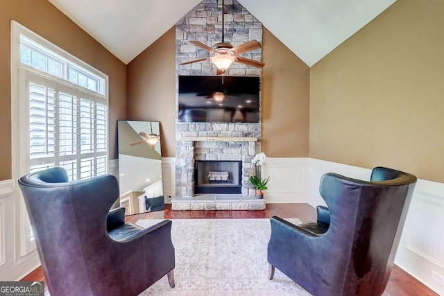 116 Archstone Sq, Mcdonough, GA 30253 - living room featuring ceiling fan, a wainscoted wall, wood finished floors, lofted ceiling, and a stone fireplace