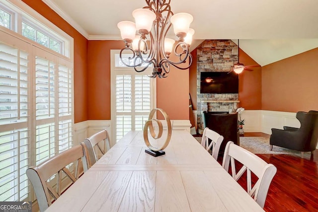 116 Archstone Sq, Mcdonough, GA 30253 - dining area with a wainscoted wall, a stone fireplace, wood finished floors, a chandelier, and a decorative wall
