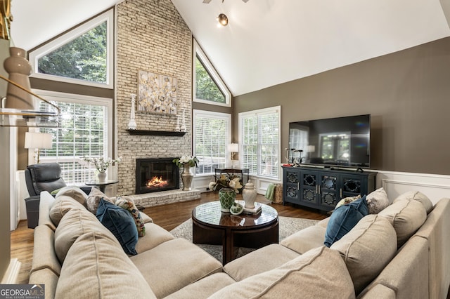 10530 Tuxford Dr, Alpharetta, GA 30022 - living room featuring high vaulted ceiling, wainscoting, wood finished floors, a brick fireplace, and a ceiling fan