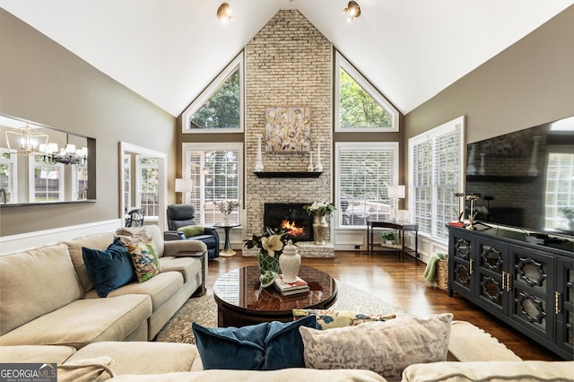 10530 Tuxford Dr, Alpharetta, GA 30022 - living room featuring high vaulted ceiling, healthy amount of natural light, a large fireplace, a chandelier, and dark wood-style flooring