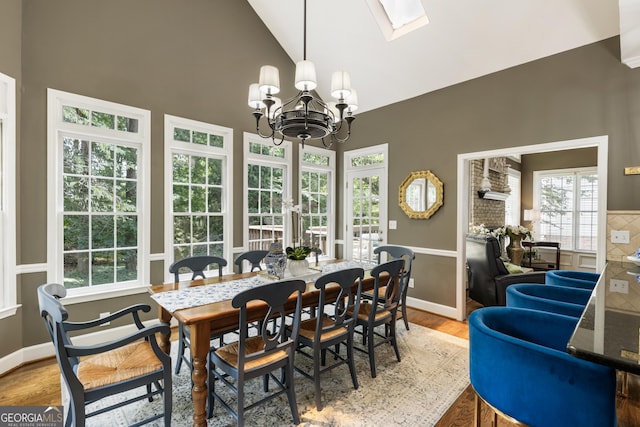 10530 Tuxford Dr, Alpharetta, GA 30022 - dining space featuring a skylight, a chandelier, light wood-style floors, and high vaulted ceiling