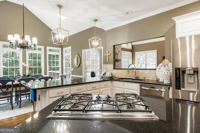10530 Tuxford Dr, Alpharetta, GA 30022 - kitchen featuring appliances with stainless steel finishes, a chandelier, white cabinetry, dark stone countertops, and tasteful backsplash