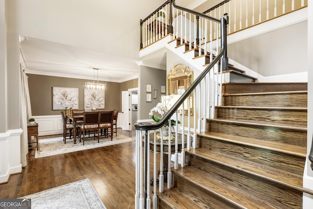 10530 Tuxford Dr, Alpharetta, GA 30022 - stairway featuring wood finished floors, ornamental molding, a chandelier, and wainscoting