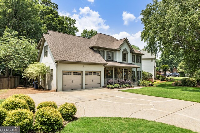 10530 Tuxford Dr, Alpharetta, GA 30022 - view of front facade featuring covered porch, an attached garage, roof with shingles, stucco siding, and driveway