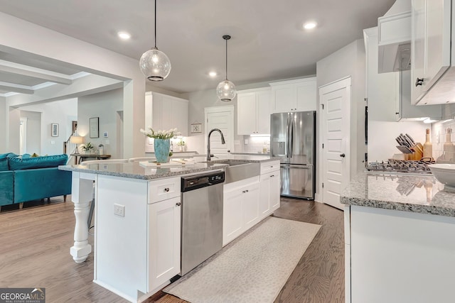 29 Peppertree Dr, Newnan, GA 30265 - kitchen with appliances with stainless steel finishes, light stone counters, wood finished floors, open floor plan, and recessed lighting