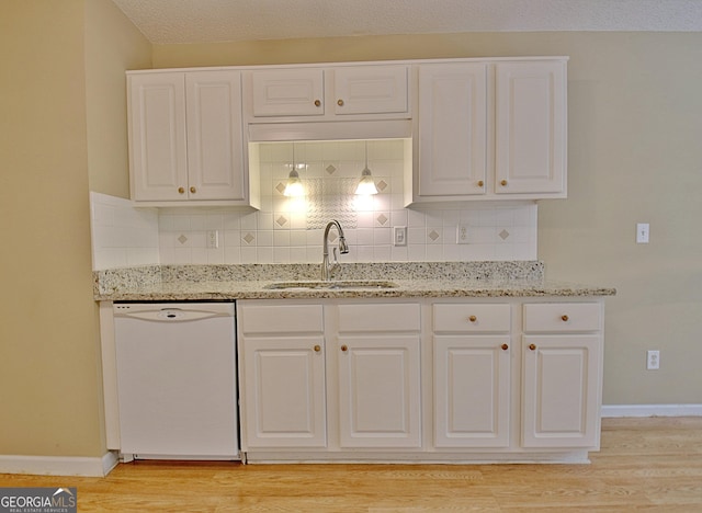 4135 Coursey Lake Rd, Douglasville, GA 30135 - kitchen with white dishwasher, light wood finished floors, decorative backsplash, and light stone counters