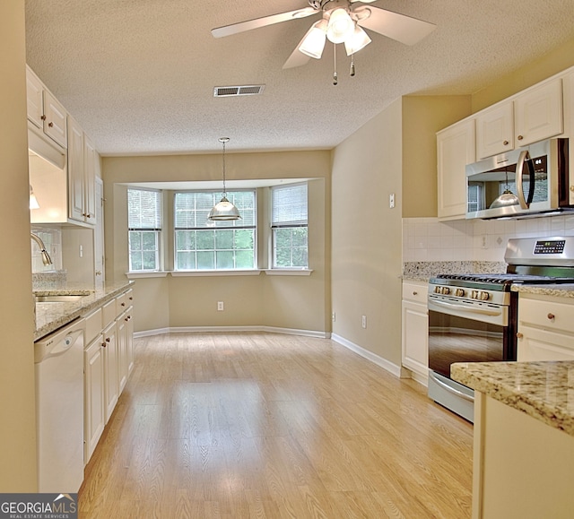 4135 Coursey Lake Rd, Douglasville, GA 30135 - kitchen with appliances with stainless steel finishes, healthy amount of natural light, tasteful backsplash, light wood-style floors, and a textured ceiling