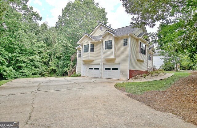 4135 Coursey Lake Rd, Douglasville, GA 30135 - view of property exterior featuring a garage, stairway, driveway, and roof with shingles