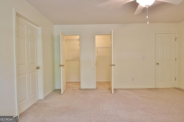 4135 Coursey Lake Rd, Douglasville, GA 30135 - unfurnished bedroom featuring light colored carpet, multiple closets, a ceiling fan, and a textured ceiling