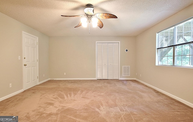 4135 Coursey Lake Rd, Douglasville, GA 30135 - unfurnished bedroom featuring light colored carpet, a textured ceiling, a closet, and ceiling fan