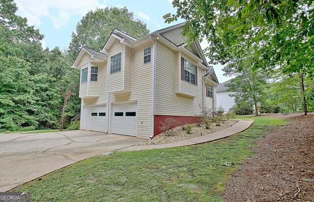 4135 Coursey Lake Rd, Douglasville, GA 30135 - view of home's exterior featuring concrete driveway and a garage