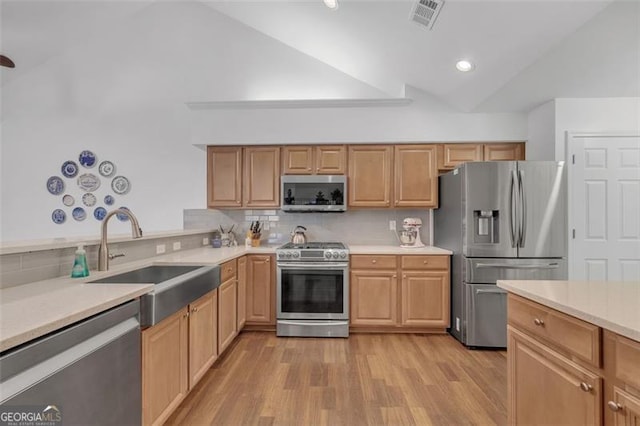 1402 Silver Smt, Conyers, GA 30094 - kitchen featuring appliances with stainless steel finishes, vaulted ceiling, light wood-type flooring, light countertops, and backsplash