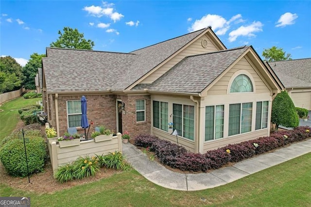 1402 Silver Smt, Conyers, GA 30094 - rear view of property featuring roof with shingles, a lawn, and brick siding