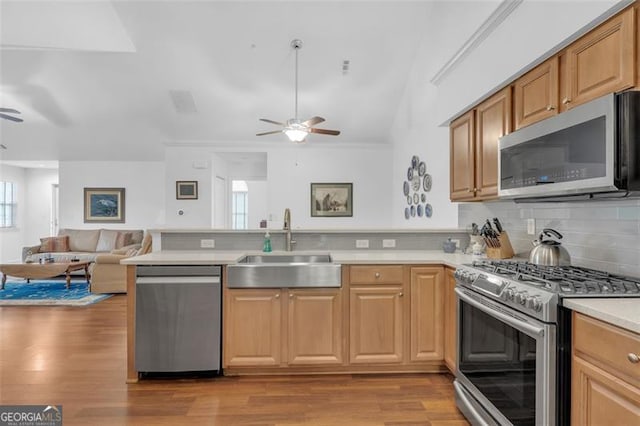 1402 Silver Smt, Conyers, GA 30094 - kitchen featuring appliances with stainless steel finishes, a ceiling fan, a peninsula, open floor plan, and vaulted ceiling