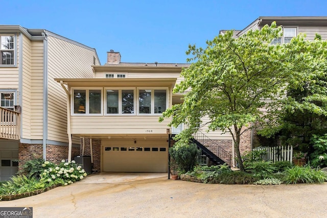 1508 Brianwood Rd Unit 1508, Decatur, GA 30033 - townhome / multi-family property featuring a garage, a chimney, concrete driveway, brick siding, and stairs