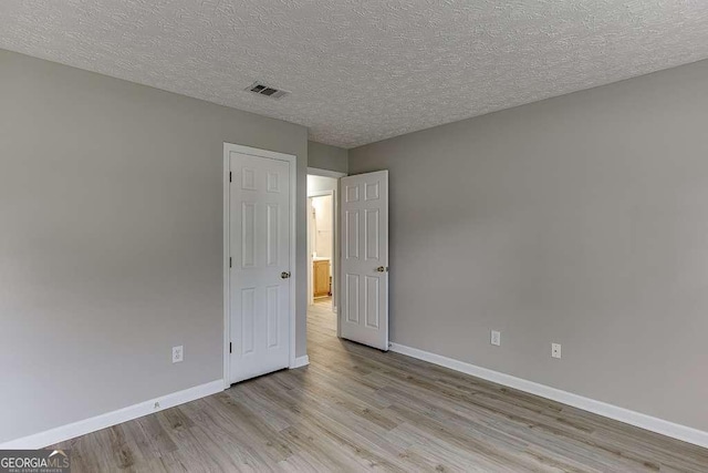 4735 Widgeon Way, Cumming, GA 30028 - unfurnished bedroom with light wood-style floors and a textured ceiling
