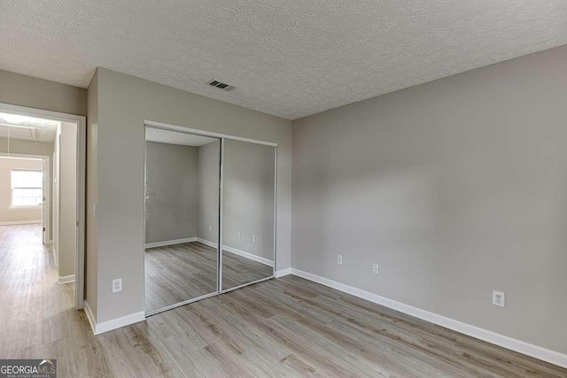4735 Widgeon Way, Cumming, GA 30028 - unfurnished bedroom featuring wood finished floors, a closet, attic access, and a textured ceiling