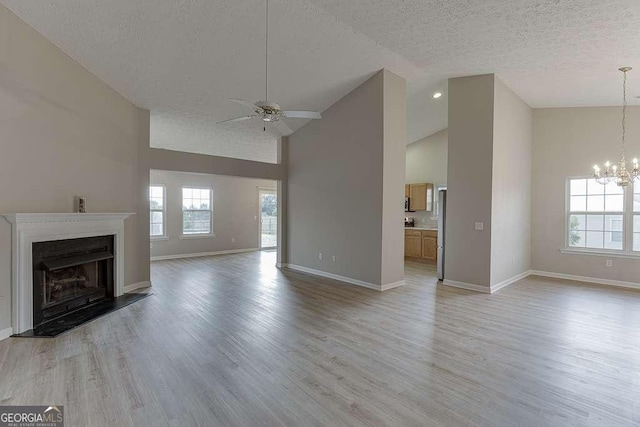 4735 Widgeon Way, Cumming, GA 30028 - unfurnished living room featuring ceiling fan, a textured ceiling, a chandelier, light wood finished floors, and a fireplace