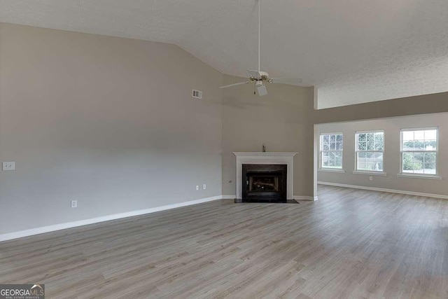 4735 Widgeon Way, Cumming, GA 30028 - unfurnished living room featuring ceiling fan, wood finished floors, a fireplace with flush hearth, high vaulted ceiling, and a textured ceiling