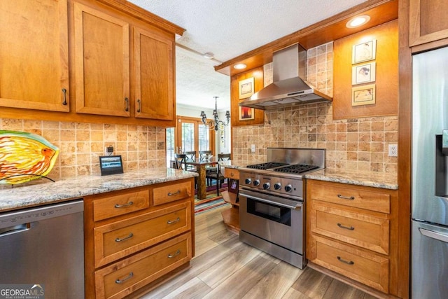 4850 Lake Fjord Pass, Marietta, GA 30068 - kitchen featuring wall chimney range hood, stainless steel appliances, a textured ceiling, brown cabinetry, and light wood-style flooring