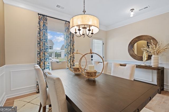 155 Roxeywood Way, Winder, GA 30680 - dining space with a chandelier, crown molding, light wood-type flooring, wainscoting, and a decorative wall