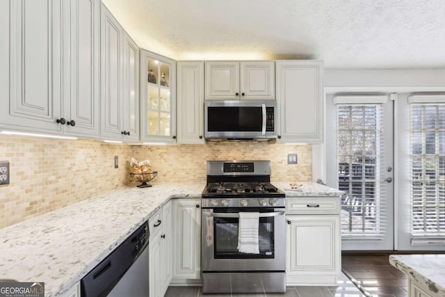10475 Willow Meadow Cir, Alpharetta, GA 30022 - kitchen featuring appliances with stainless steel finishes, plenty of natural light, light stone countertops, and a textured ceiling