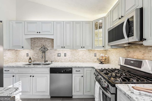 10475 Willow Meadow Cir, Alpharetta, GA 30022 - kitchen with stainless steel appliances, vaulted ceiling, decorative backsplash, light stone countertops, and glass insert cabinets