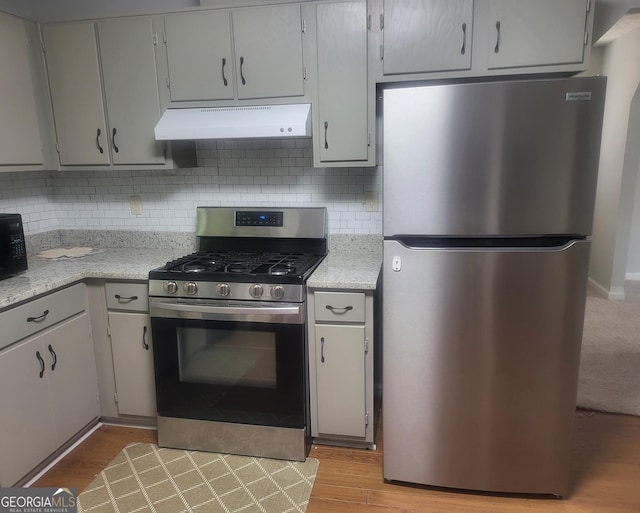 6118 Dana Ct Unit 6, Lithonia, GA 30058 - kitchen featuring stainless steel appliances, under cabinet range hood, decorative backsplash, and light wood-style flooring