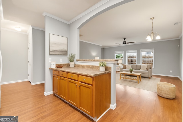 7177 Fringe Flower Dr, Austell, GA 30168 - kitchen with arched walkways, light wood-style floors, a ceiling fan, a peninsula, and crown molding