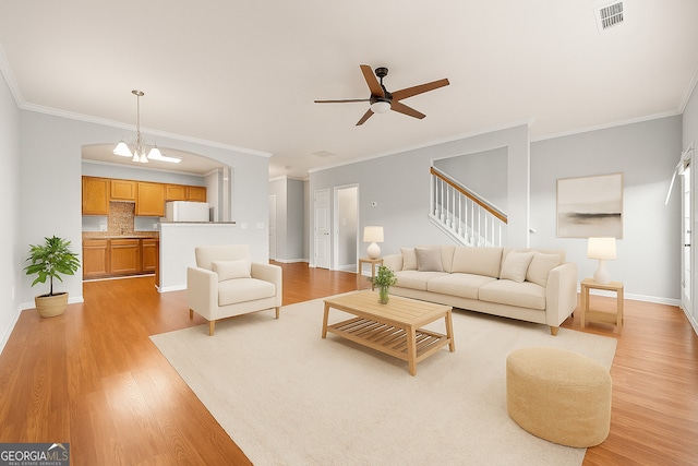 7177 Fringe Flower Dr, Austell, GA 30168 - living room featuring light wood-style flooring, ceiling fan, crown molding, and stairs
