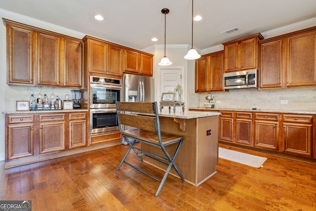 117 Elkins Blvd, Locust Grove, GA 30248 - kitchen featuring stainless steel appliances, a kitchen bar, crown molding, tasteful backsplash, and a center island