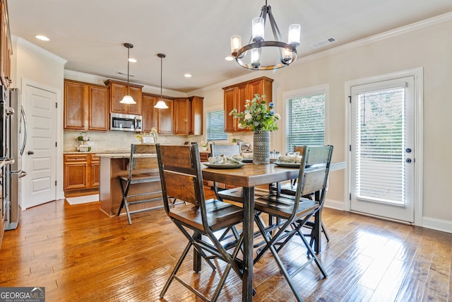 117 Elkins Blvd, Locust Grove, GA 30248 - dining area with a chandelier, light wood-style floors, crown molding, and recessed lighting